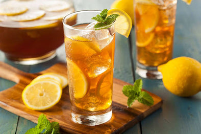 Best Honey Cocktails For Summer - Glass of iced tea with lemon and mint garnish.